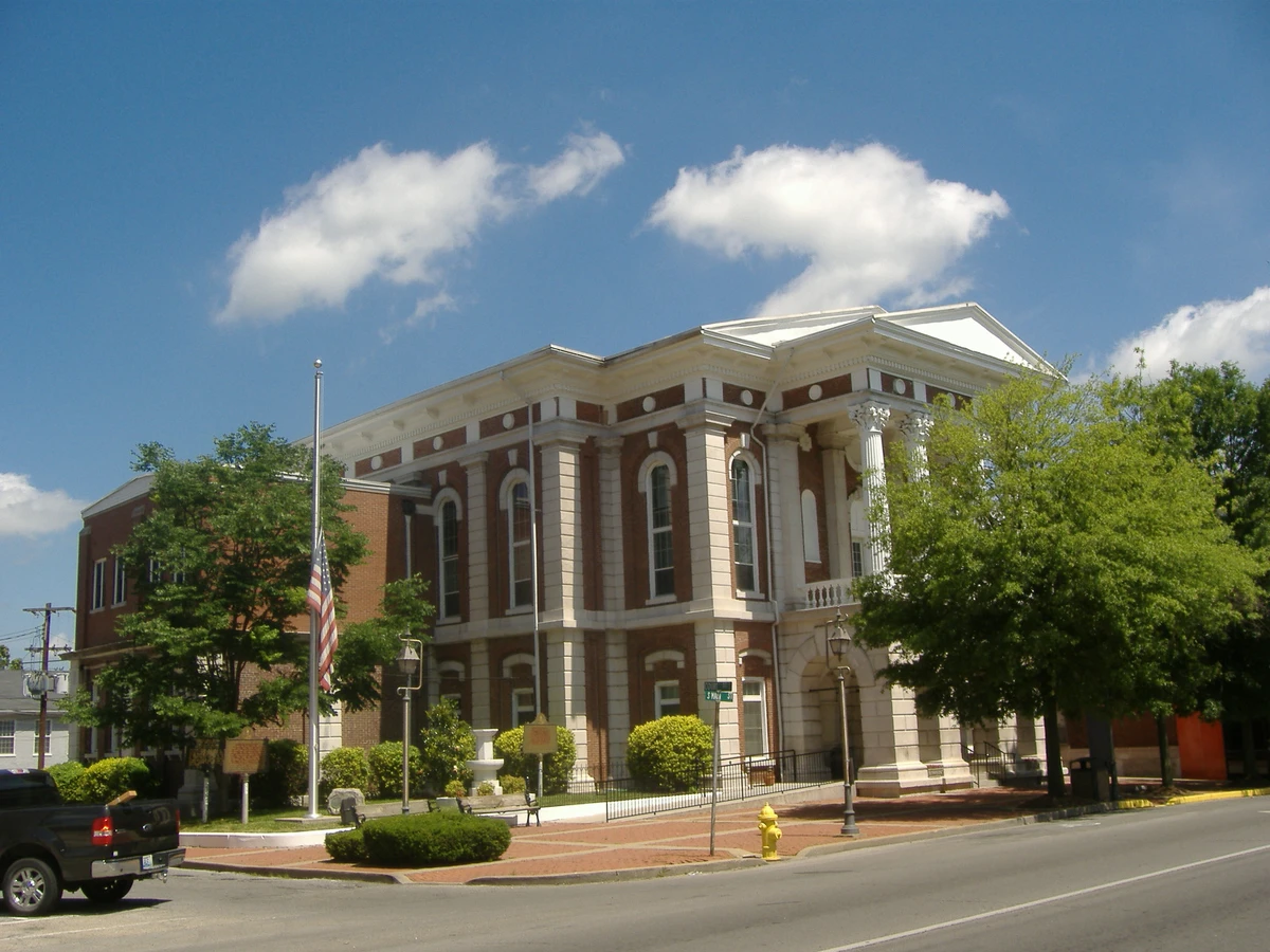 The red brick and white stone Christian County Courthouse in Hopkinsville, Kentucky, on a sunny day with a flag out front
