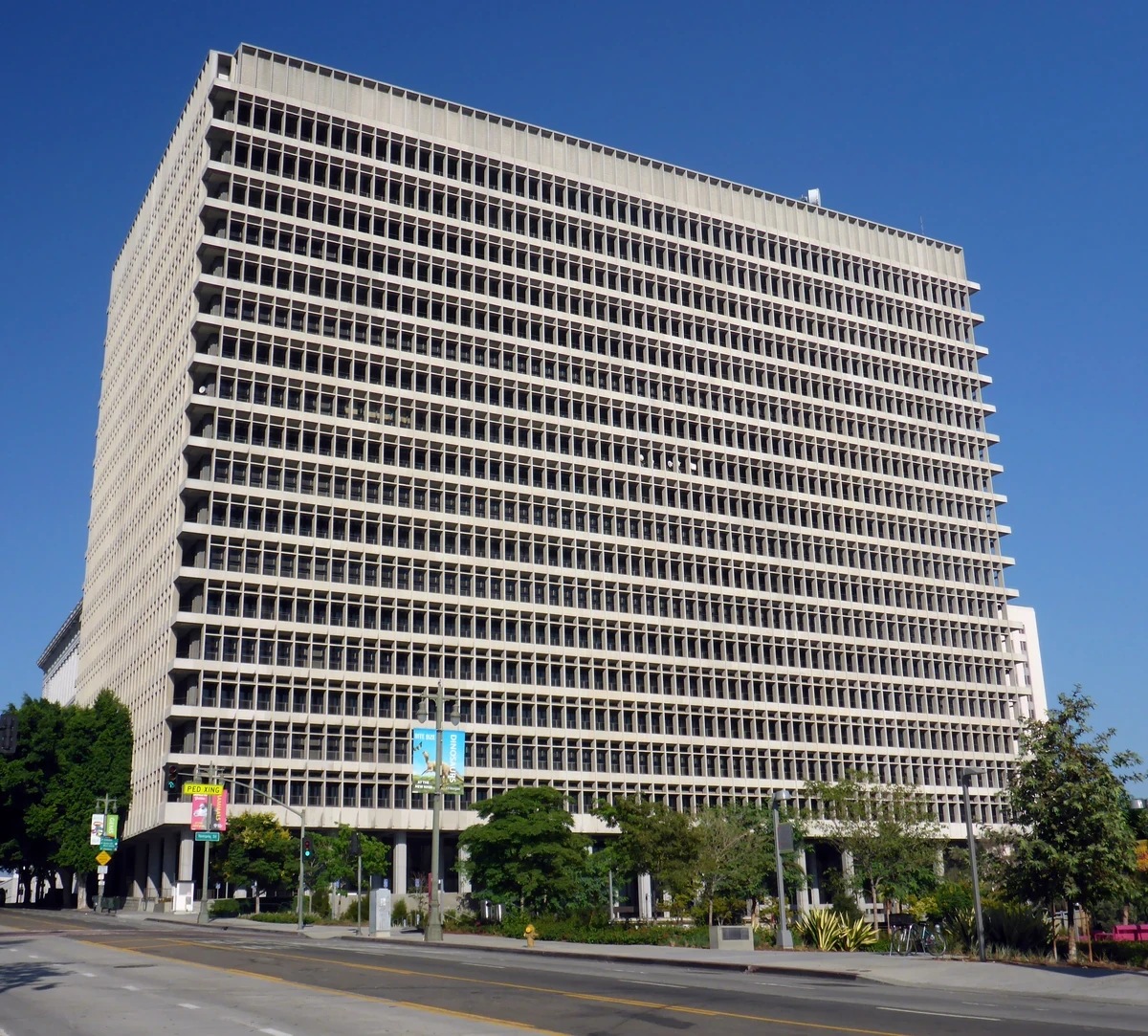The Clara Shortridge Foltz Criminal Justice Center in downtown Los Angeles, a tall pale concrete tower with rows of deep set windows under a clear blue sky