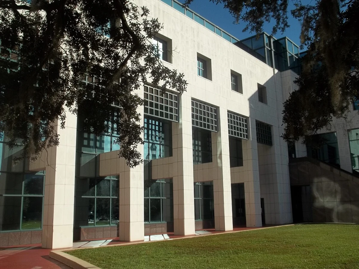 The white stone and glass Leon County Courthouse in Tallahassee, Florida, framed by live oak branches
