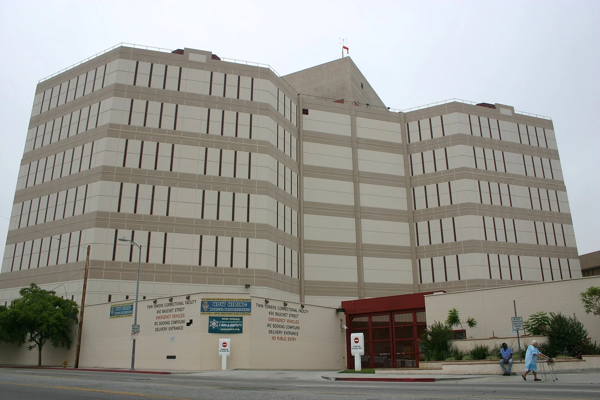 The tall tan concrete Twin Towers Correctional Facility in Los Angeles, with a wall sign for the IRC booking compound and a no public entry notice