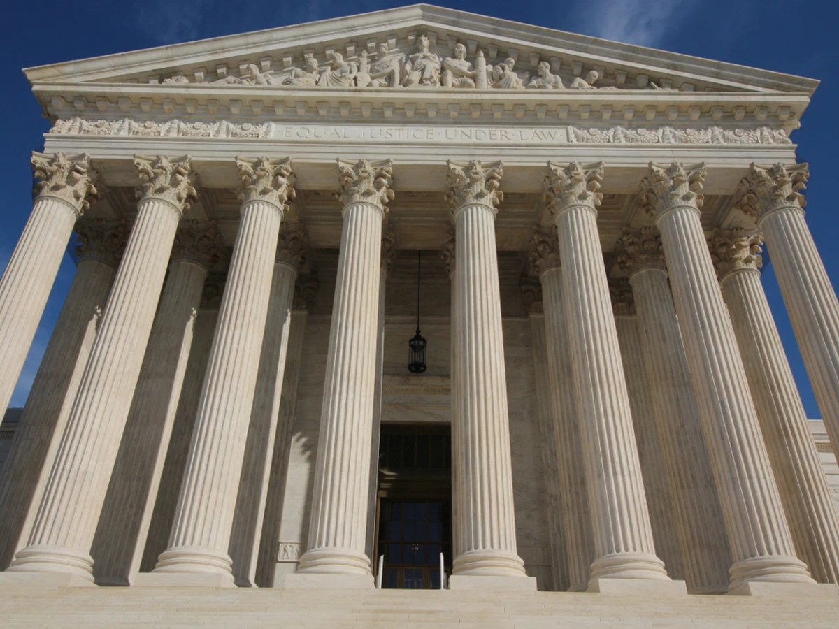 Looking up at the white marble columns of the U.S. Supreme Court Building in Washington, DC, with the words Equal Justice Under Law above the entrance